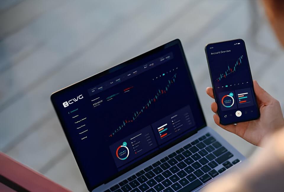 A person using a laptop and smartphone to monitor stock market data and place trades.